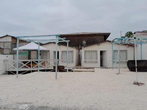 Cabanas bahia inglesa في باهيا انغليسا: مجموعة منازل على الشاطئ مع مراجيح