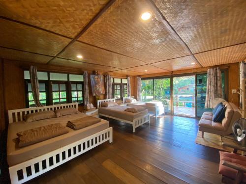 a bedroom with two beds and a living room at วังภูไพร ฟาร์มสเตย์ in Wang Nam Khieo