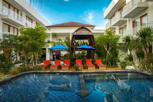 a pool at a hotel with chairs and umbrellas at Abian Harmony Hotel in Sanur