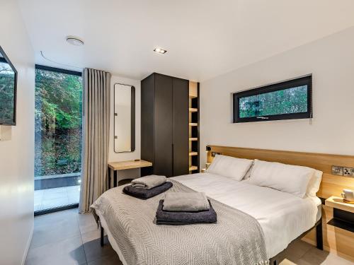 a bedroom with a bed with two towels on it at The Pump House Lodge in Elslack