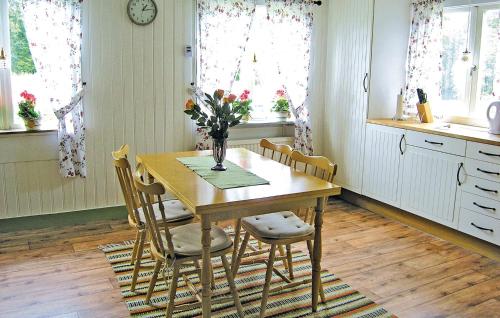 a dining room table with chairs and a vase of flowers at Holiday Home Ambjörnarp Lx in Emtashult