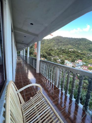 a balcony with benches and a view of a mountain at Hotel Berena in San Marcos La Laguna