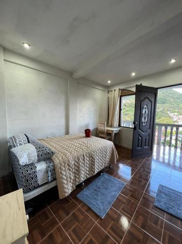 1 dormitorio con cama, mesa y ventana en Hotel Berena, en San Marcos La Laguna