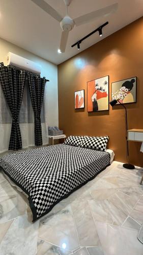 a bedroom with a black and white bed in a room at Bonjour Homestay in Sungai Pelik