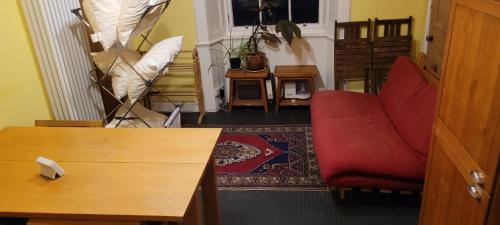 ein Wohnzimmer mit einem roten Sofa und einem Tisch in der Unterkunft City centre Flat - sleep upto 4 in Edinburgh