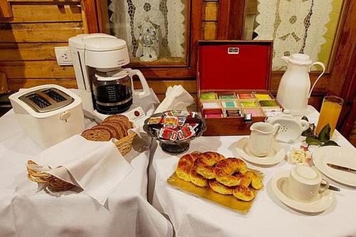 una mesa con cafetera y algunos pasteles. en Tango B&B en Ushuaia