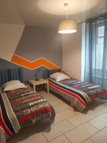 une chambre avec deux lits, une table et une lampe dans l'établissement home ferman, à Saint-Dyé-sur-Loire