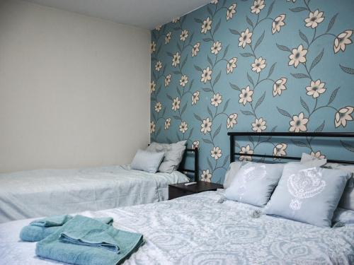 Coastal Retreat - Uk37827 في Bare: سريرين في غرفة بها زهور على الحائط