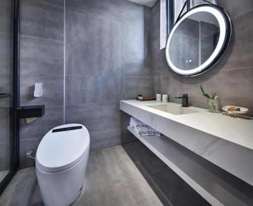 a bathroom with a white toilet and a mirror at Lanshan Moon Resort in Yangshuo