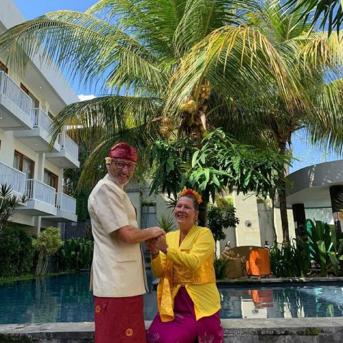 a man and a woman standing in front of a pool at Abian Harmony Hotel in Sanur