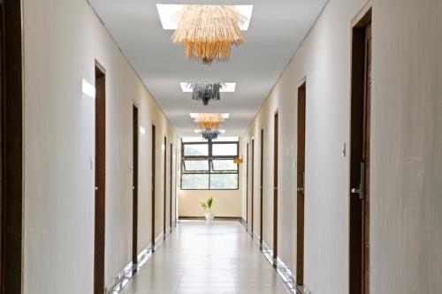 a hallway with white walls and a chandelier at Abian Harmony Hotel in Sanur