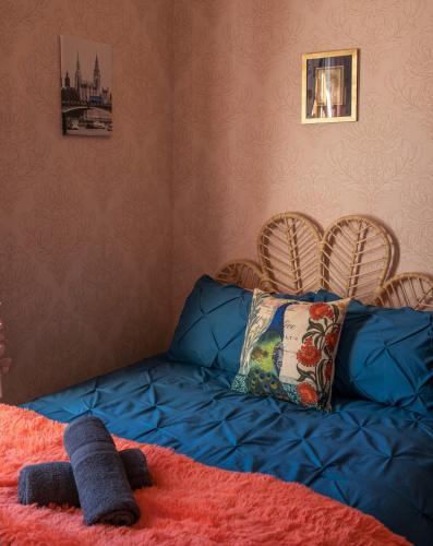 a bedroom with a blue bed with two chairs at Ruapehu's 5-Star OLD POST OFFICE - 1-4 Bdr West Wing in Owhango
