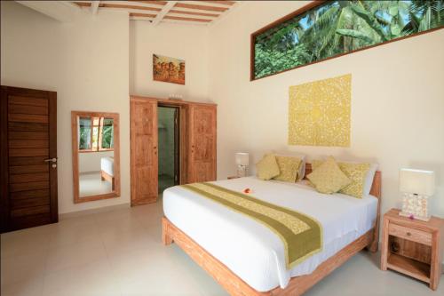 a bedroom with a large bed and a tv on the wall at Villa Serenity in Candidasa
