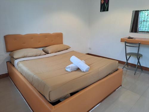 una cama con una almohada blanca encima en ไวท์ เอลเลแฟนต์ รีสอร์ท, en Nakhon Nayok