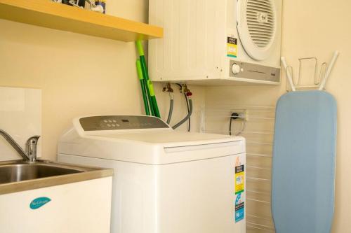 a small kitchen with a sink and a refrigerator at Blayney Retreat-Central & Comfortable in Blayney