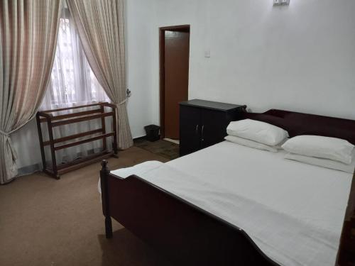 a bedroom with a large bed and a window at Silver Rose Holiday Home in Nuwara Eliya