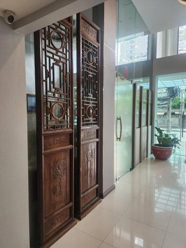 a pair of wooden doors in a hallway at August Residence in Bangkok