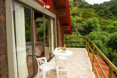 a balcony with a white table and chairs on it at Eco Cabañas San Lorenzo in La Mesa