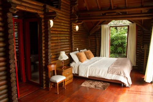 1 dormitorio con 1 cama en una cabaña de madera en Eco Cabañas San Lorenzo, en La Mesa