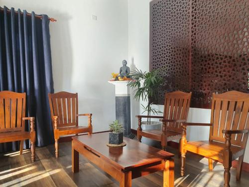 ein Wohnzimmer mit Stühlen, einem Tisch und einem Kamin in der Unterkunft Belihull Vila in Nuwara Eliya