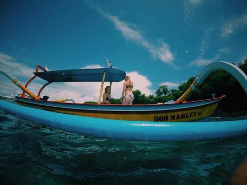 two people in a blue boat on the water at SNORKELING AT PADANGBAI BY KAI TRIP TOMORROW in Padangbai