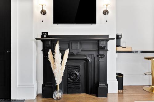 a black fireplace with a flat screen tv above it at The Coach House in Salem