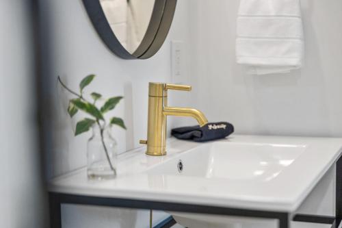 a bathroom sink with a gold faucet and a mirror at The Coach House in Salem