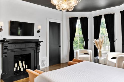 a living room with a fireplace and a tv at The Coach House in Salem