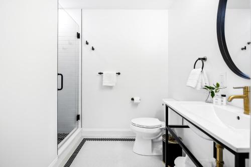 a white bathroom with a shower and a toilet at The Coach House in Salem