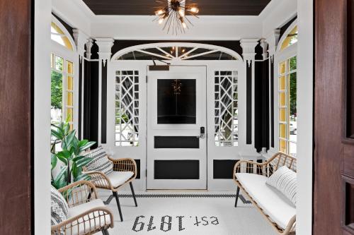 a front porch with a white door and a chandelier at The Coach House in Salem