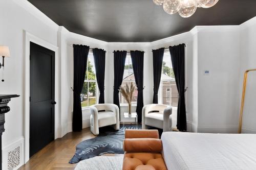 a bedroom with a bed and chairs and a chandelier at The Coach House in Salem