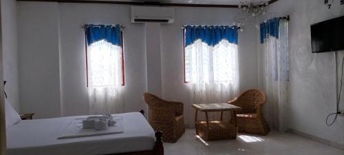 a bedroom with a bed and a table and chairs at Princess of Coron Austrian Resort in Coron