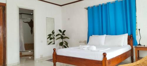 a bedroom with a bed with a blue curtain at Princess of Coron Austrian Resort in Coron