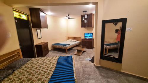 a room with a bedroom with a mirror and a bed at Godwill Kimo Guest house Seraulim in Madgaon