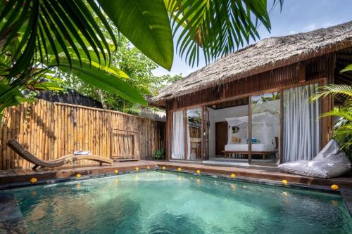a swimming pool in front of a villa at Villa Markisa Echo Beach in Canggu