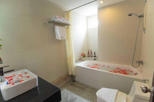 a bathroom with a tub and a toilet and a sink at Hoang Sa Hotel in Danang