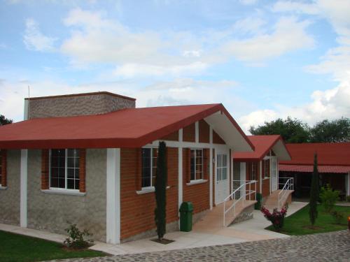 a small house with a red roof at Los Ócalos Villas in Huasca de Ocampo