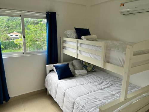 a bedroom with two bunk beds and a window at Armonia De Las Terrenas Gorgeous Penthouse in Las Terrenas