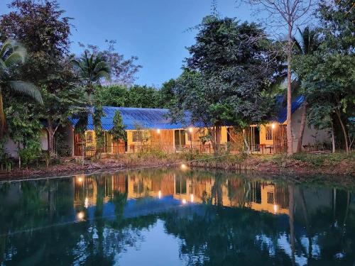 a house with a pond in front of it at Baan Thamachart in Watthana Nakhon