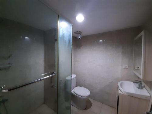 e bagno con doccia, servizi igienici e lavandino. di Cozy Tamansari Hive Cawang by Bonzela Property a Giacarta