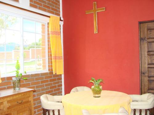 a dining room with a table and a cross on the wall at Los Ócalos Villas in Huasca de Ocampo
