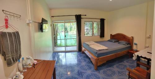 a bedroom with a bed in a room with a window at Baan Thamachart in Watthana Nakhon