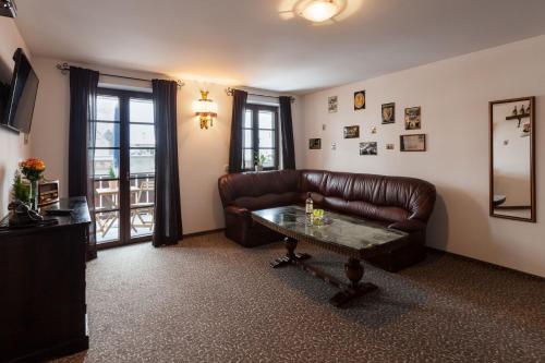 a living room with a leather couch and a table at Vitusfort Appartement "Guinness Suite" in Füssen