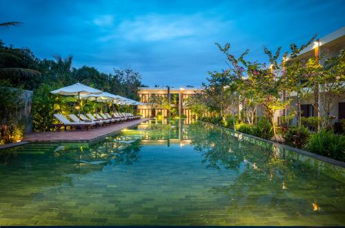 a pool at the resort at night at Khmer House Resort in Siem Reap