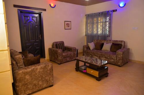 a living room with couches and chairs and a table at Living Green APARTMENTS AIRPORT PICK UP in Benin City