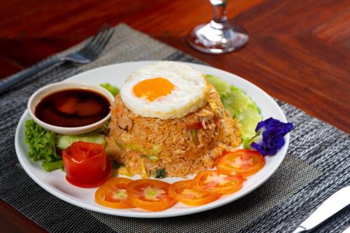 a plate of food with a fried egg and vegetables at Khmer House Resort in Siem Reap