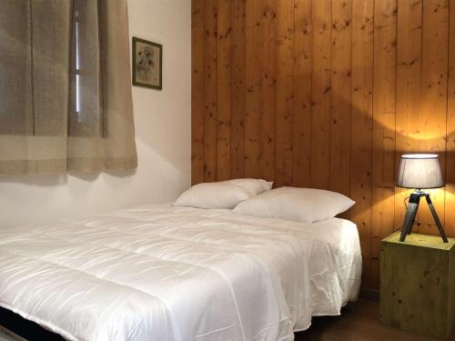 - une chambre avec un lit blanc et un mur en bois dans l'établissement Appartement Luz-Saint-Sauveur, 2 pièces, 5 personnes - FR-1-402-85, à Luz-Saint-Sauveur