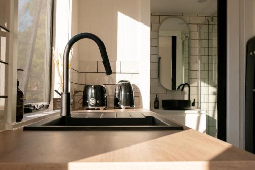 a kitchen counter with a sink and a mirror at Wild Life Cabin 1 - Grampians in Halls Gap