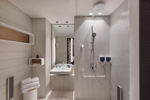 a bathroom with a shower and a sink at Port Tower by Isrotel Design in Tel Aviv