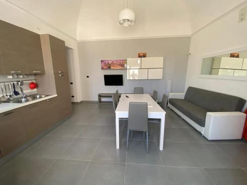 eine Küche und ein Wohnzimmer mit einem Tisch und einem Sofa in der Unterkunft Nicola’s house in Procida
